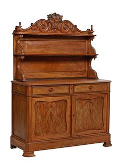 French Provincial Saint Hubert Style Carved Walnut Sideboard, 19th c., with a fruit basket crest flanked by applied socles, to two graduated reeded ed
