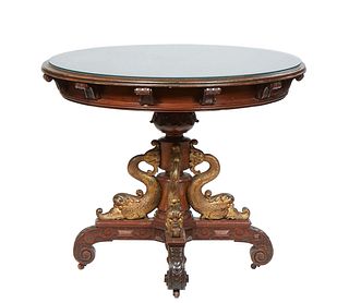 Unusual Carved Mahogany Center Table, 19th c., in the manner of R.J. Horner, the ogee edge circular top on bracket supports to a wide skirt, on a carv
