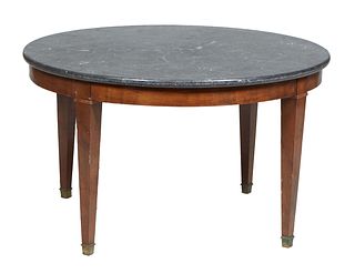 French Fruitwood Marble Top Coffee Table, 20th c., the circular black marble on a base, to four legs terminating in Brass Cap casters, H.- 23 in., Dia