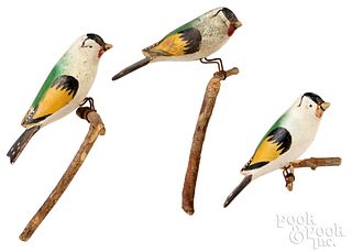 Three carved and painted birds on perches