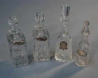 Four cut crystal decanters with silver labels