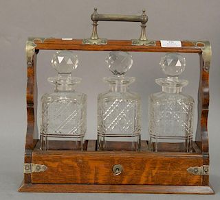 Victorian tantalus having three crystal bottles with stoppers in oak case, ht 13 1/2in.