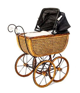 * An English Caned Doll Pram, Width 21 inches.