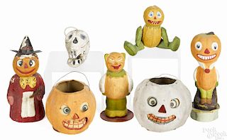 Seven composition Halloween candy containers, mostly German, to include jack-o-lanterns, a skull