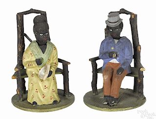 Pair of composition black Americana nodders, probably German, having figures seated in twig chairs