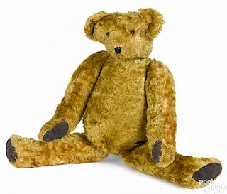 Early jointed teddy bear with elongated limbs, leather pads, and a hump, 18'' h.