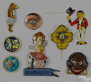 Eight German tin lithograph animated pull string toys, to include a girl sitting on a chamber pot