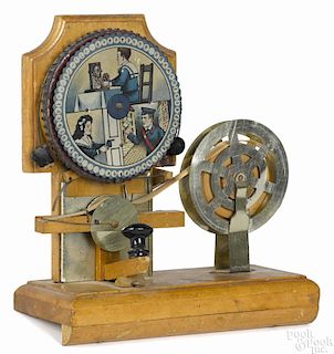 Toy ticker tape device, tin lithograph and painted wood with a rubber type wheel, 8 1/2'' h.