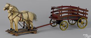Horse drawn wood wagon pull toy with a pair of fabric covered horses on a shaped platform