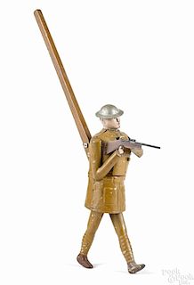 Unusual painted tin soldier cap shooting push toy holding a gun with a roll of caps