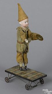 German bisque doll playing cymbals automated pull toy with a paper lithograph covered platform