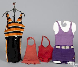 Four vintage children's bathing suits, together with a wrought iron counter store display rack