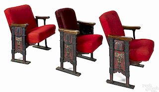 Three theater seats with cast iron, floral motif supports, two seats with a single decorated side