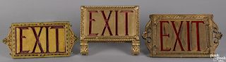 Three theater Exit signs, translucent red panels behind gesso wood frames