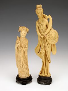 TWO CARVED RESIN STATUES ON STANDS