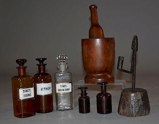 19th C. mortar and pestle, five apothecary bottles and a 18th/19th C. rush light/mortar