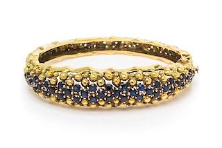 * An 18 Karat Yellow Gold and Sapphire Bangle Bracelet, Jack Gutschneider Co., 35.70 dwts.