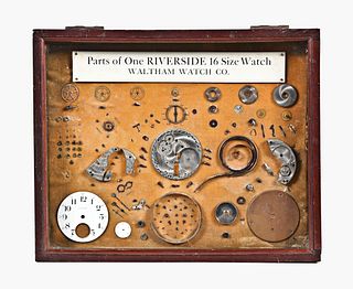 An early 20th century jewelers display featuring a disassembled Riverside pocket watch movement