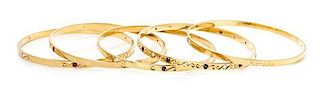 * A Collection of 18 Karat Yellow Gold, Diamond, Ruby and Sapphire Bangle Bracelets, 61.80 dwts.