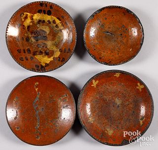 Four redware plates, early 19th c.