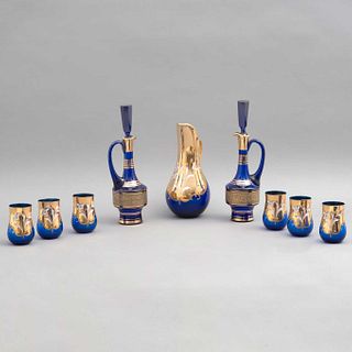 LOTE DE LICORERAS, JARRA Y VASOS. ITALIA, SXX. Elaborados en cristal de Murano, color azul. Decorados con esmalte dorado y motivos flor