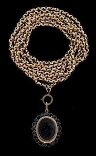 An Victorian long gold guard belcher chain with a garnet portrait locket pendant attached. Chain length 148 cm. Tested as 9ct