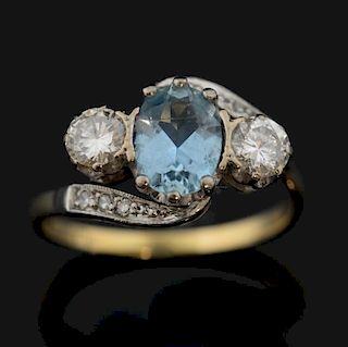 Aquamarine and diamond three stone ring, crossover setting, oval cut aquamarine flanked by round brilliant cut diamond each w
