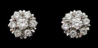 A pair of diamond cluster earrings, each set with seven round brilliant cut diamonds in a claw setting. Mounted in 18ct gold.