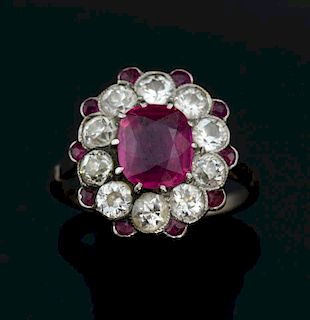 Edwardian ruby and diamond cluster ring, with central ruby of 2.44 carats within a border of ten millgrain set diamonds, and 
