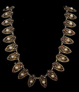 Early 20th C Continental  necklace. each section comprising a shield motif  set with pearl and garnet, mounted in silver gilt