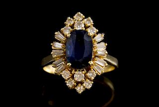 Sapphire and diamond cluster ring, set with an oval cut sapphire within  a surround of baguette and round brilliant cut diamo