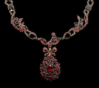 A Georgian garnet set necklace, comprising of open work garland and floral motif  the centre piece of pear shape with a bow t