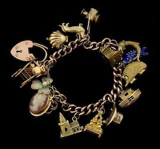 Gold charm bracelet with fourteen charms,  including plique-a jour enamel clover, Noah's ark and Spanish guitar on chair