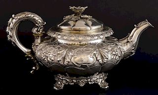George IV silver teapot of melon fluted form moulded with flowers and foliage with flowerhead finial, on four shell feet, by 