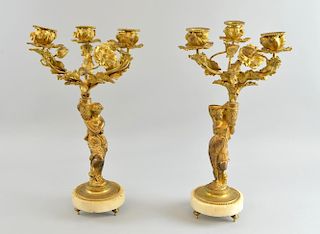 Pair of 19th century gilt metal three light candelabra, figural columns, circular marble bases to shaped feet, 35cm high,