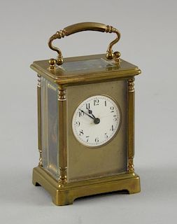 Brass carriage clock in red leather carrying case. 15 cm high