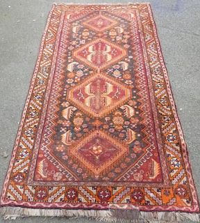 Persian red ground rug with four lozenge shaped medallions 250cm x 127cm
