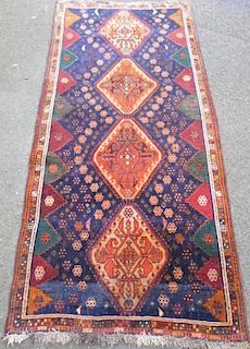 Persian  blue ground rug with four lozenge shaped medallions 224cm x 107cm