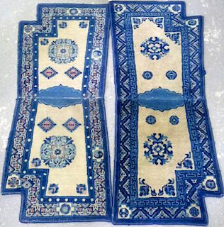Five Chinese woollen saddle carpets, cream ground with blue borders,