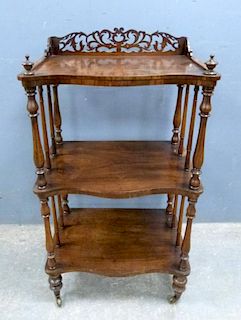 Victorian rosewood serpentine fronted whatnot with pierced gallery to the top and turned columns, on casters 99cm x 55cm