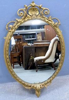 Oval gilt framed mirror with beaded border and scrolling decoration, 112cm x 69cm,