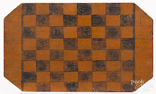 Painted pine gameboard, 19th c., retaining its original orange and black surface, 12 3/4'' x 21 1/2''.