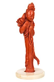 A CHINESE CARVED RED CORAL FIGURE OF A GUANYIN HOLDING A LOTUS