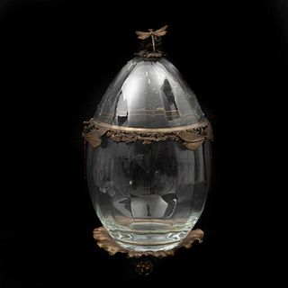 URNA SIGLO XX Elaborada en vidrio transparente y metal  Diseño a manera de huevo Decoración floral y remate con libélula D...