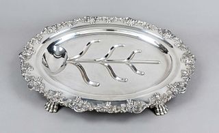 Large oval asparagus tray, 20th century, plated, on 4 paw feet, matching curved relief decoration rim, mirror with depression, total l. 56 cm