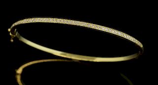 Diamond set hinged bangle, with round brilliant cut diamonds in a pave setting in 18ct yellow gold.