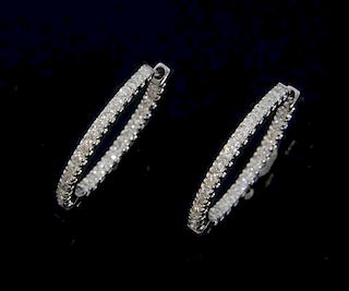 A pair of diamond hoop earrings, set with round brilliant cut diamonds to each side, hinged, mounted in 18ct white gold. Leng