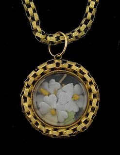 Victorian gold locket and chain, the locket containing fabric flowers.