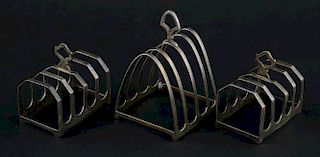 Pair of George V silver four division toast racks with loop handles, London, 1935 and another toast rack of arched form,, 7oz