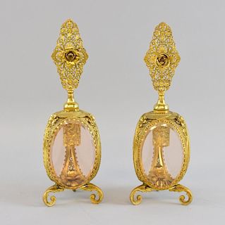 Pair of gilt metal and glass scent bottles and stoppers, each on three scroll feet, each 26cm high,